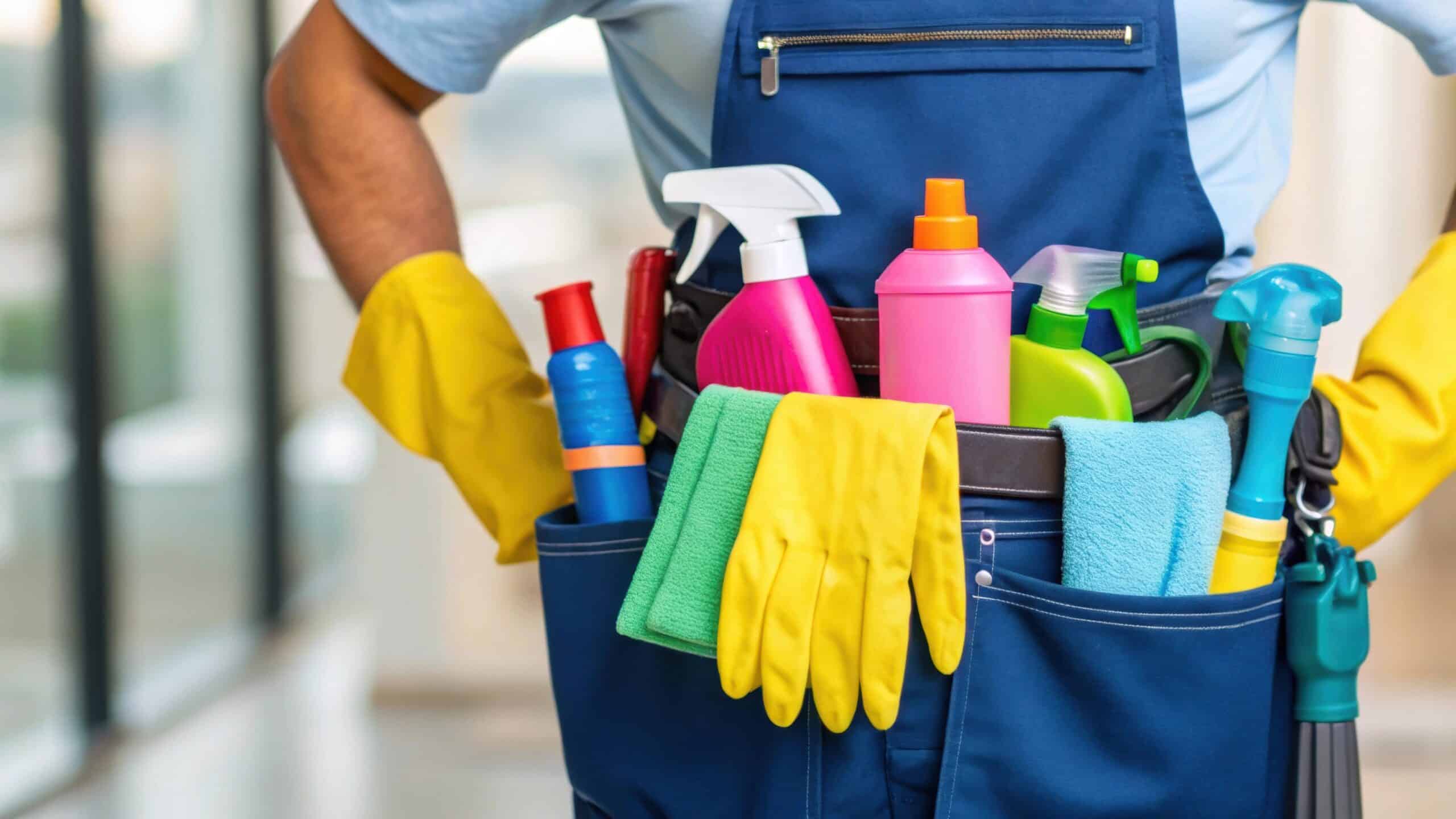 With a medium closeup framing the cleaners torso colorful spray bottles and cloths are visible in their utility belt as they prepare to tackle spills embodying efficiency in